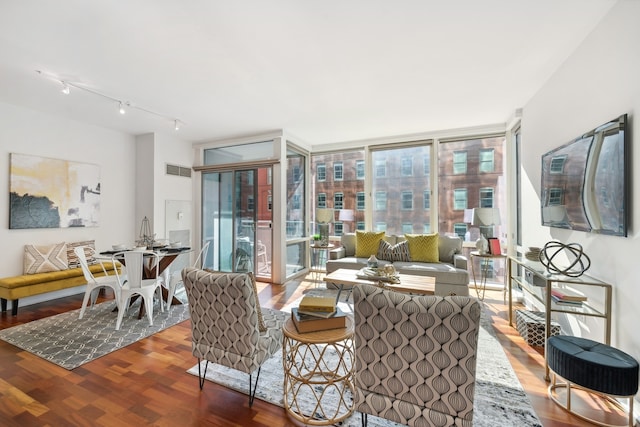 living room featuring dark hardwood / wood-style floors, plenty of natural light, and rail lighting