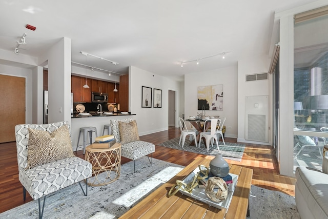 living room featuring light hardwood / wood-style floors, sink, and track lighting