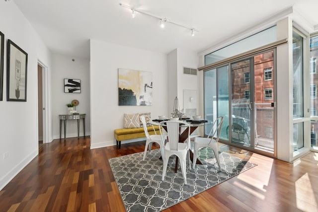 dining room with dark wood-type flooring and rail lighting