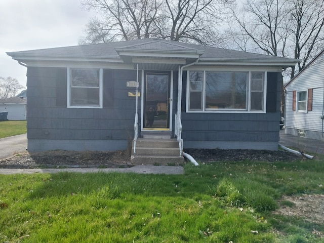 bungalow-style home with a front lawn