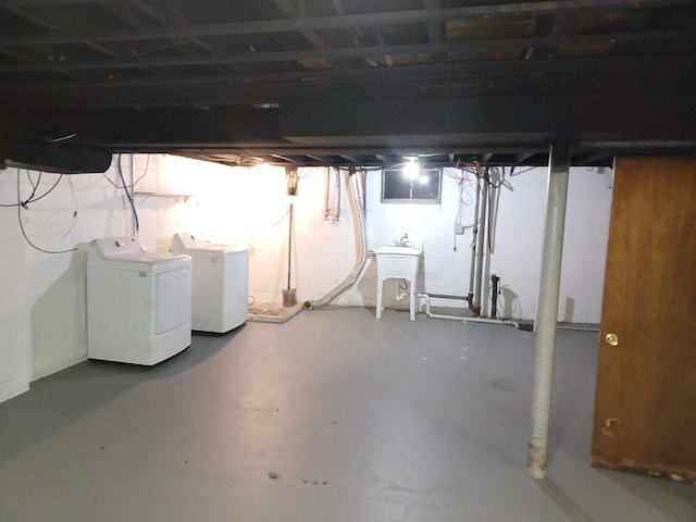 basement featuring independent washer and dryer and sink