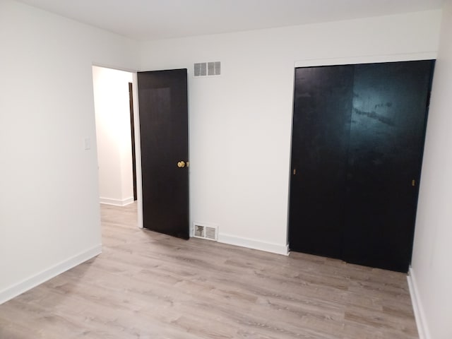 unfurnished bedroom with a closet and light hardwood / wood-style flooring