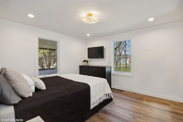 bedroom featuring multiple windows and hardwood / wood-style floors