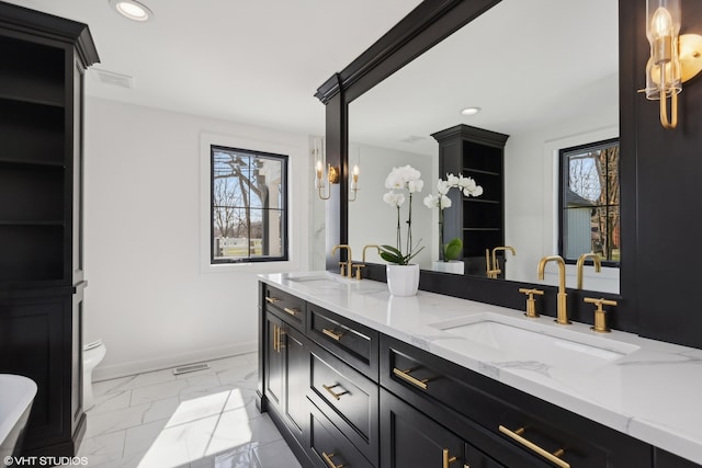 bathroom featuring vanity, toilet, and plenty of natural light