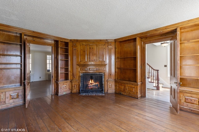 unfurnished living room featuring a textured ceiling and dark hardwood / wood-style flooring