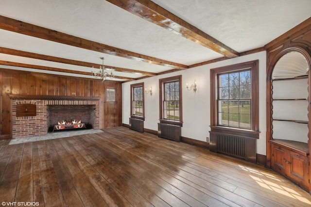 unfurnished living room with a fireplace, beamed ceiling, hardwood / wood-style flooring, and radiator heating unit