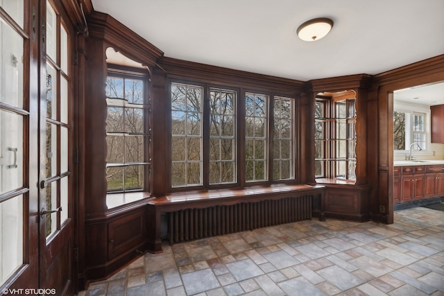 unfurnished sunroom with radiator heating unit and sink