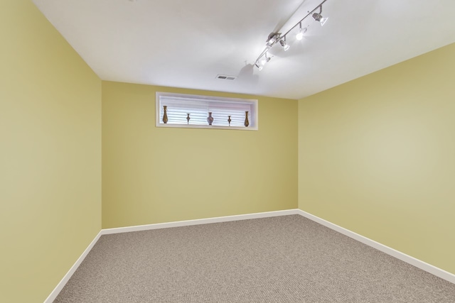 carpeted empty room with track lighting