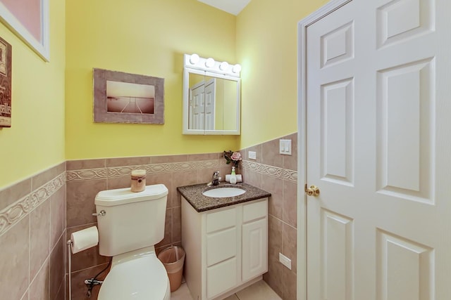 bathroom featuring tile walls, vanity, and toilet