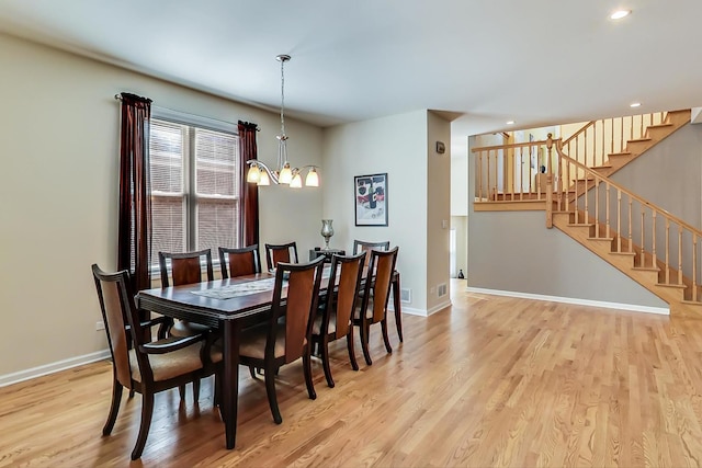 dining space featuring light hardwood / wood-style flooring and a notable chandelier