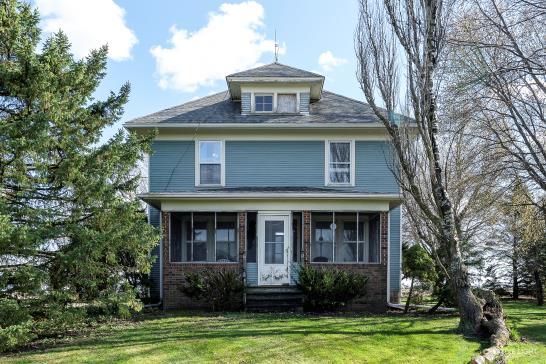 view of front of property featuring a sunroom and a front lawn