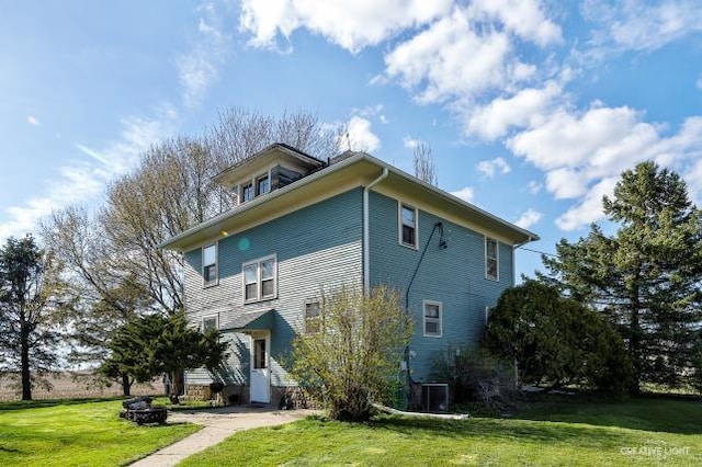 exterior space with central AC and a lawn