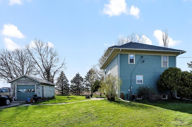 view of side of home with a garage, a yard, and an outdoor structure