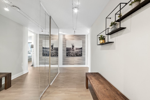 hall featuring track lighting and light wood-type flooring