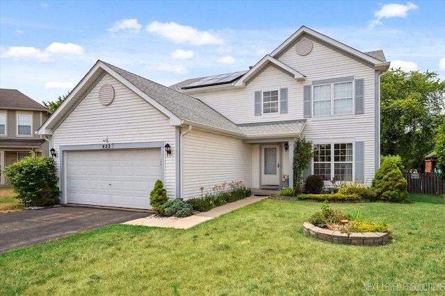 422 Rachel Cir, Romeoville, IL 60446 - traditional home with solar panels, an attached garage, asphalt driveway, a front lawn, and a shingled roof