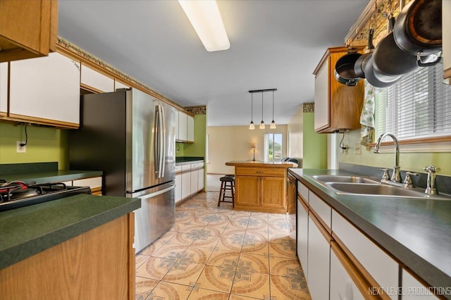 422 Rachel Cir, Romeoville, IL 60446 - kitchen featuring dark countertops, hanging light fixtures, light tile patterned flooring, appliances with stainless steel finishes, and a peninsula
