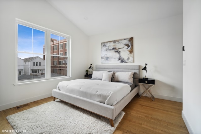 bedroom featuring lofted ceiling and light wood-type flooring