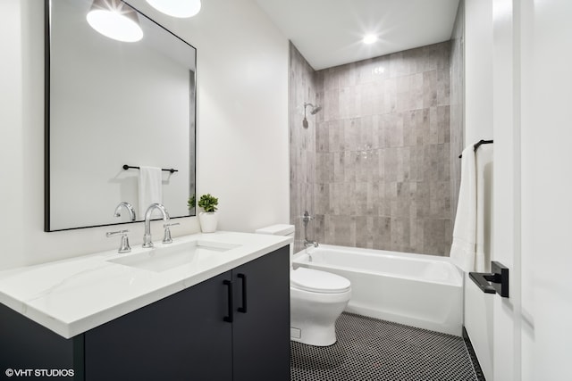 full bathroom with tile flooring, tiled shower / bath, toilet, and vanity