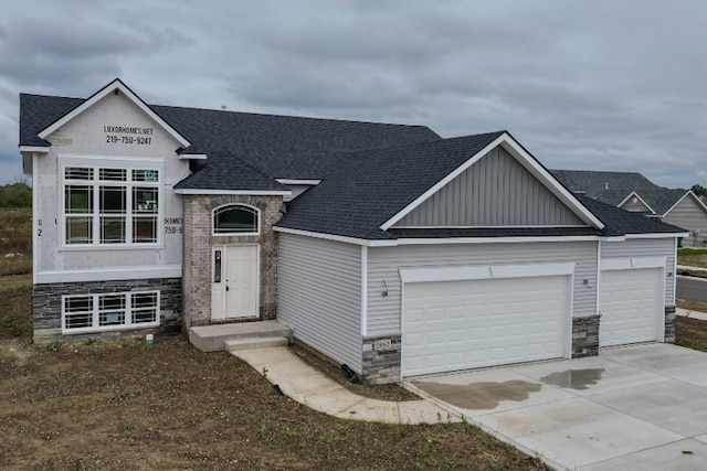 view of front facade with an attached garage, stone siding, concrete driveway, and roof with shingles