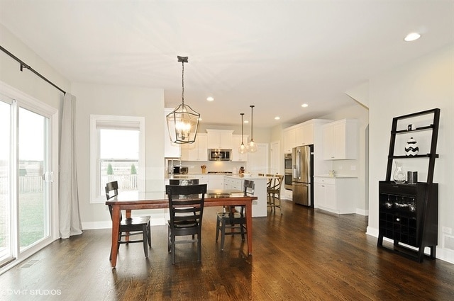 dining space with dark hardwood / wood-style flooring and a chandelier