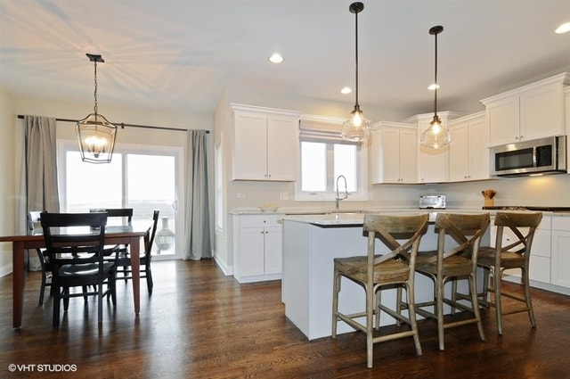 kitchen with a kitchen island, dark hardwood / wood-style floors, and white cabinetry