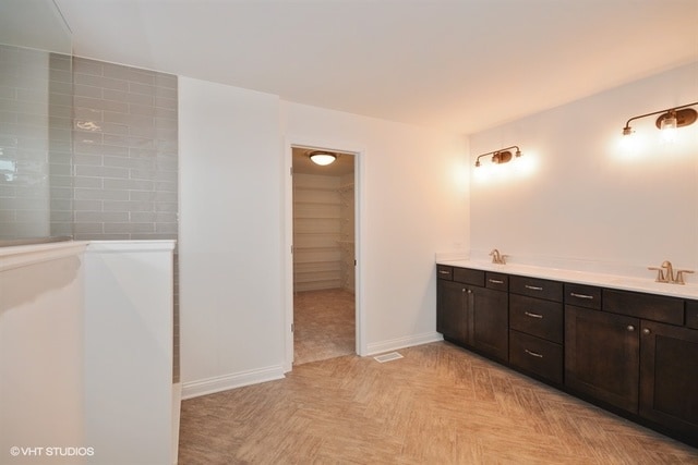 bathroom featuring parquet flooring and dual bowl vanity