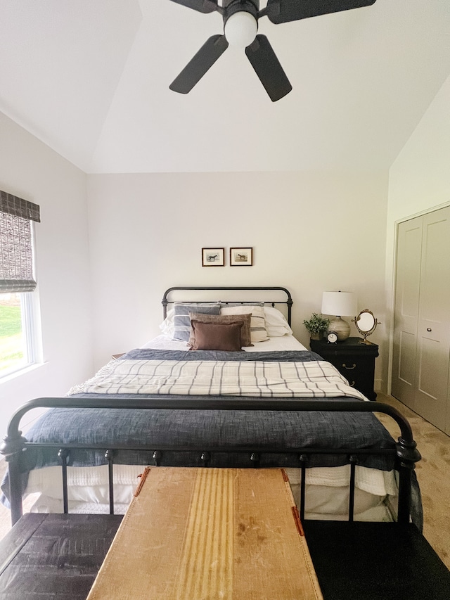 bedroom with ceiling fan, a closet, carpet floors, and vaulted ceiling