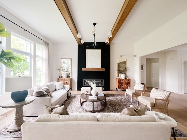 living room with beamed ceiling and light hardwood / wood-style floors