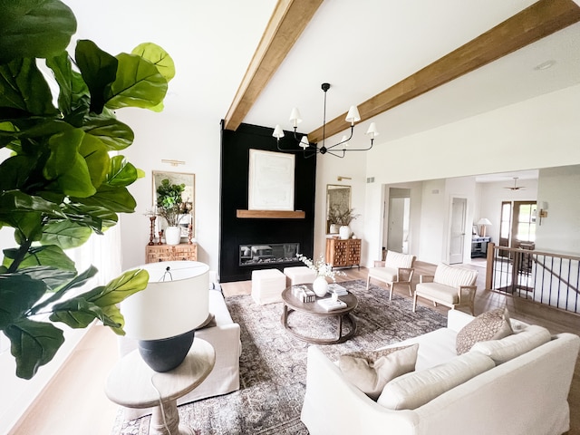 living room featuring beam ceiling, hardwood / wood-style flooring, and a chandelier