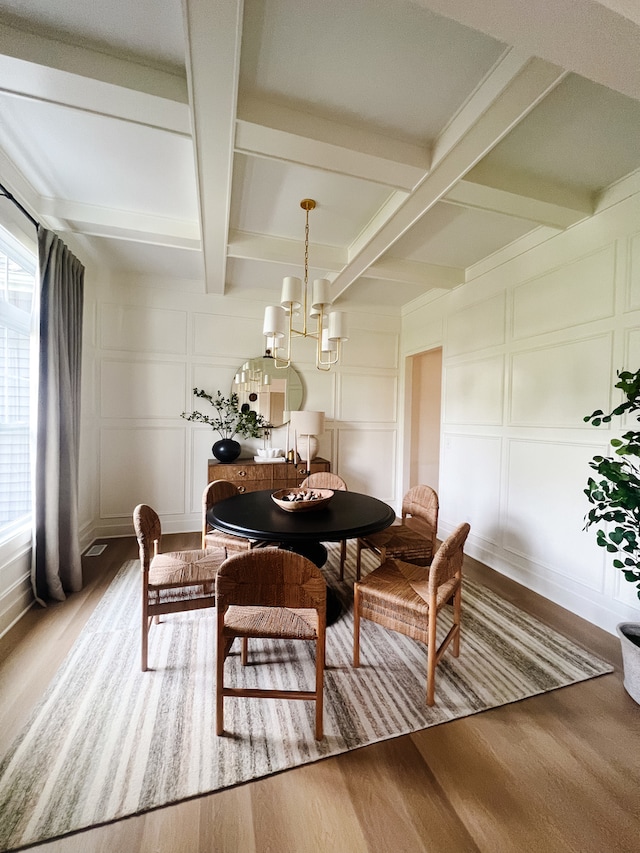 dining room featuring beam ceiling, an inviting chandelier, light hardwood / wood-style flooring, and a healthy amount of sunlight