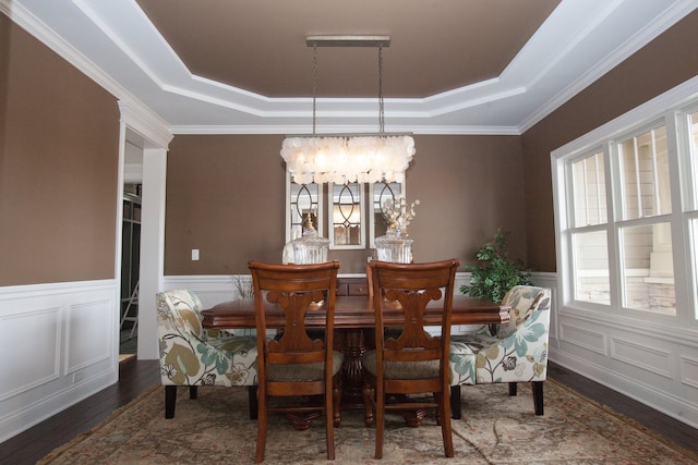 dining room featuring a notable chandelier, ornamental molding, dark hardwood / wood-style floors, and a raised ceiling