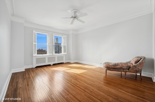 unfurnished room featuring hardwood / wood-style flooring, ornamental molding, radiator, and ceiling fan