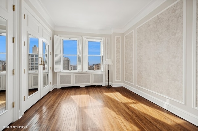 empty room featuring crown molding and hardwood / wood-style flooring