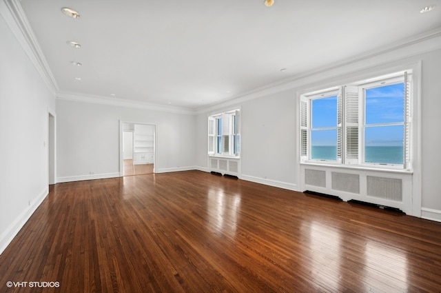 empty room with a water view, dark hardwood / wood-style floors, radiator, and crown molding