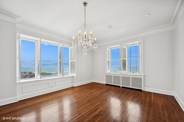 unfurnished room with ornamental molding, radiator, dark hardwood / wood-style floors, and an inviting chandelier