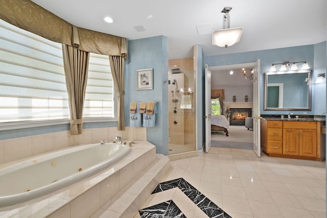 bathroom with plus walk in shower, vanity, and tile patterned flooring