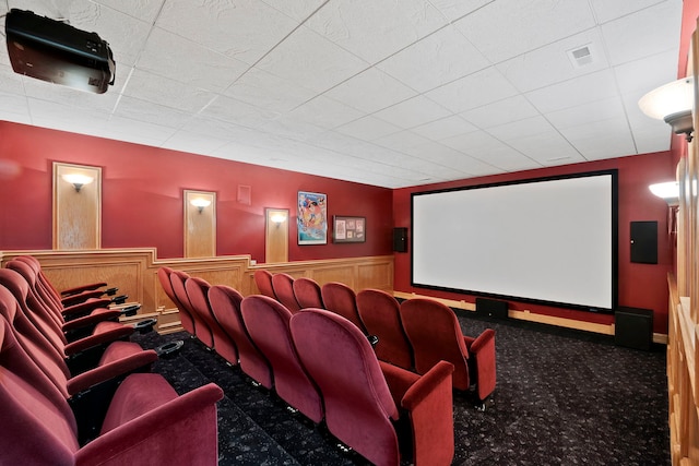 cinema with dark colored carpet and a paneled ceiling