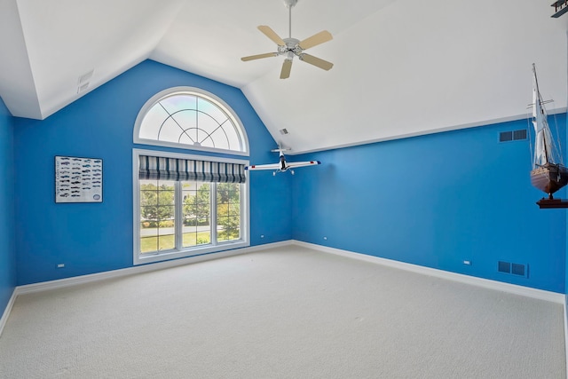 empty room featuring vaulted ceiling, carpet floors, and ceiling fan