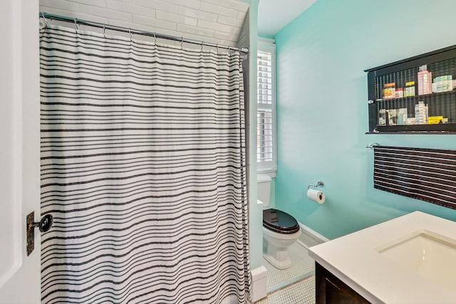 bathroom featuring vanity, toilet, and tile flooring