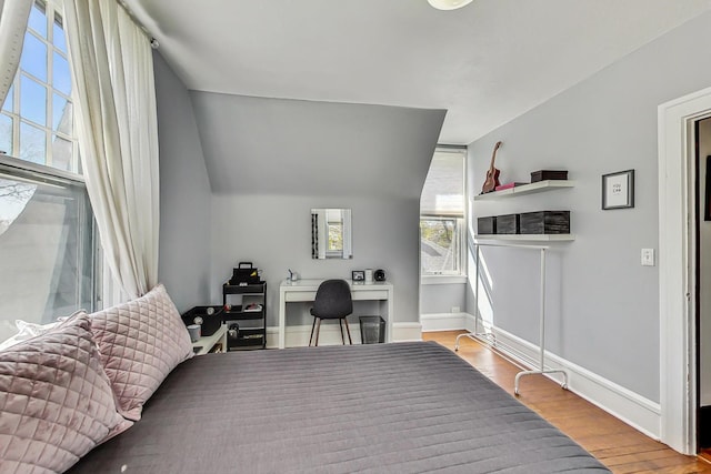 bedroom featuring light hardwood / wood-style floors and lofted ceiling