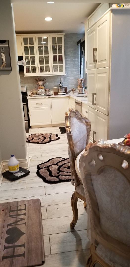 kitchen with stove, white cabinetry, and tasteful backsplash