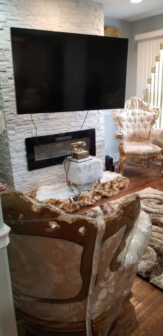 interior space featuring a stone fireplace and wood-type flooring