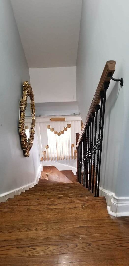 stairs with dark hardwood / wood-style flooring and vaulted ceiling