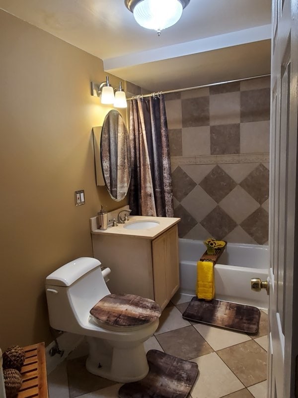 full bathroom featuring tile flooring, toilet, vanity, and shower / bath combo with shower curtain