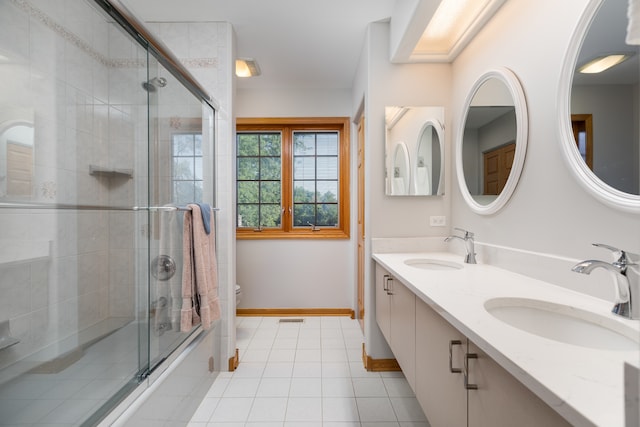 bathroom featuring double vanity, tile floors, and toilet