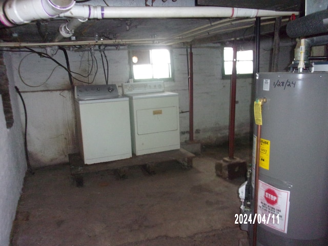 basement with water heater and washing machine and clothes dryer