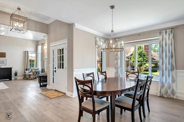 dining space featuring ornamental molding, a chandelier, and light wood-type flooring