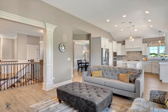 living room with light wood-type flooring, decorative columns, and lofted ceiling