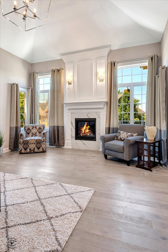 living room with light hardwood / wood-style flooring, a notable chandelier, and lofted ceiling