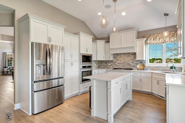 kitchen with light hardwood / wood-style flooring, backsplash, pendant lighting, and stainless steel appliances